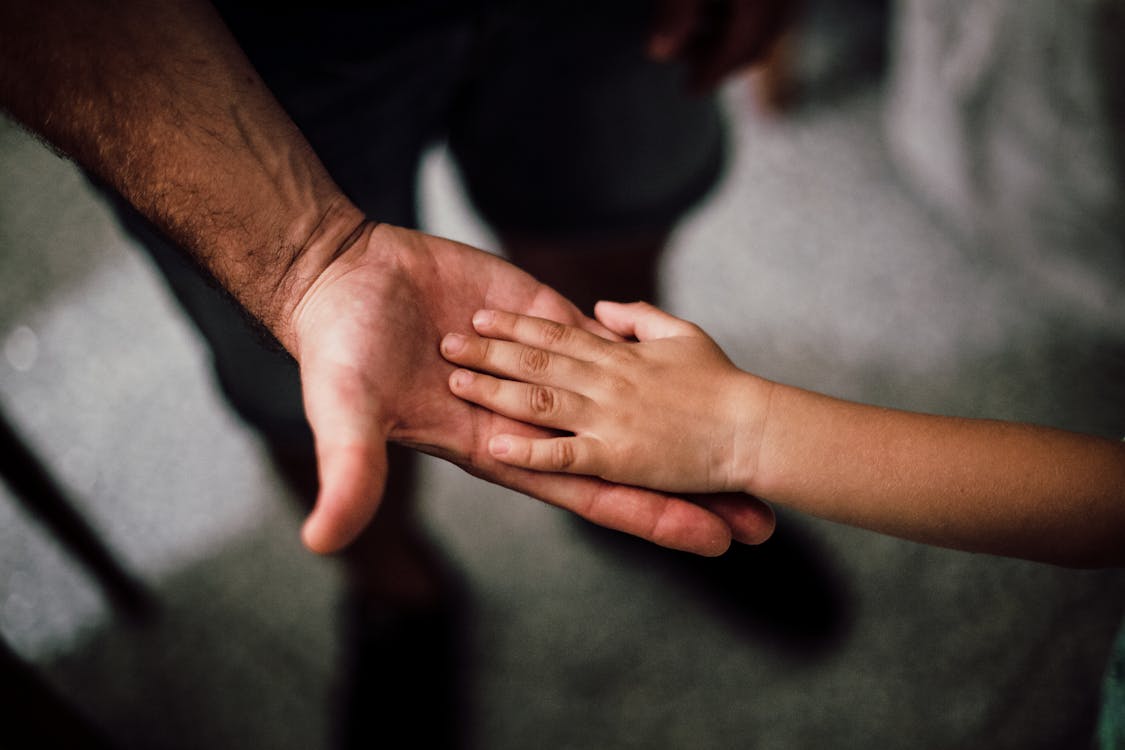 Father and child's hands together — a warm image representing the bond between parent and adult child